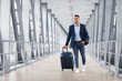 © Prostock-studio - Portrait of young middle eastern man walking in airport terminal with luggage