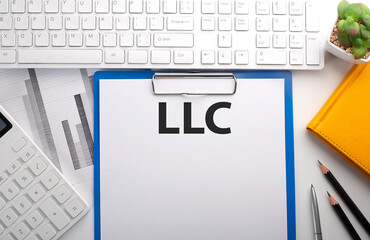 Poster - LLC written on the paper with keyboard, chart, calculator and notebook