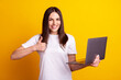 Photo of young cheerful lady show thumb-up advertising approve use laptop isolated over yellow color background