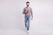 © Tetiana - Full size photo of young guy walk drink morning coffee espresso latte isolated over grey color background