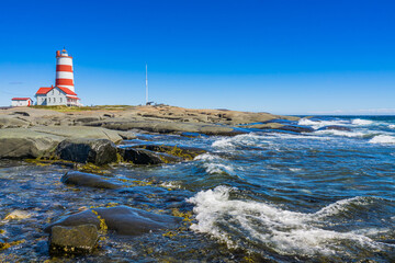 Wall Mural - View on the Pointe des Monts lighthouse, the most famous lighthouse of Cote region of Quebec, Canada