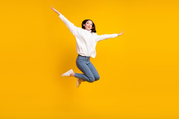 Wall Mural - Photo of romantic lady jump plane flight blow air kiss wear white hoodie jeans shoes isolated yellow color background