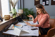 © Dragana Gordic - Confident businesswoman uses a digital tablet to video chat with a colleague before a meeting. Smiling businesswoman in a video call using tablet PC in the office.