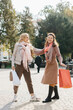 © dsheremeta - Senior female girlfriends discussing shopping while walking the city streets.