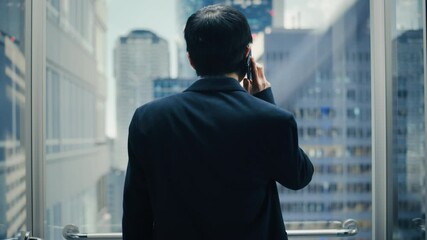 Poster - Successful Stylish Japanese Businessman Riding Glass Elevator to Office in Modern Business Center. Handsome Happy Man Talking on a Phone, Taking an Important Business Call in a Lift.