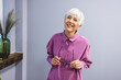 © Dragana Gordic - Portrait of mature woman with eyeglasses on grey background. Portrait of cheerful mature woman standing against grey wall. Happy mid woman looking at camera against grey background with copy space