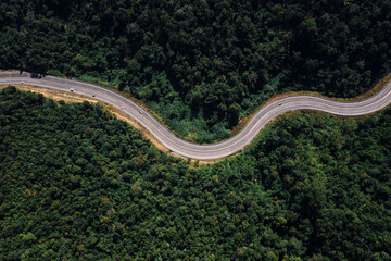 Wall Mural - long road curved in valley connecting countryside in the rainforest and the verdant hill forest at northernmost part of Thailand