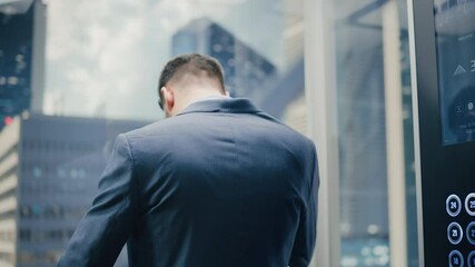 Poster - Successful Businessman in a Suit Riding Glass Elevator to Office in Modern Business Center. Handsome Serious Man Talking on a Phone, Taking an Important Business Call in a Lift.