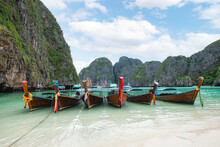 Wooden Long-tail Boats Anchored On Maya Bay With Limestone Mountain Range And Turquoise Sea In Phi Phi Island At Krabi, Thailand