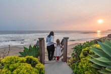 USA, California, Cayucos, Mother And Daughter (4-5) On Stairway To Beach At Sunset