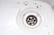 A sink drain hole with limescale or lime scale and rust on it, dirty rusty bathroom washbowl