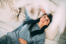 Portrait Of A Young Dreamy Girl On The Bed In Blue Pajamas In A Cozy Bedroom