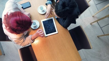 Top view of two business women on a meeting in a coffee shop, discussing strategy and business ideas. Start up company, young successful people concept