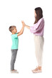 © Pixel-Shot - Little boy and his older sister giving each other high-five on white background