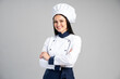 Chef woman wearing uniform and cap standing arms crossed and posing over isolated grey background. Occupation concept