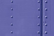 A metal surface with rivets, painted in trendy tone of Very Peri 17-3938. Color of the Year 2022.