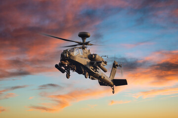 Apache attack helicopter flying in the sunset sky