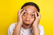 Close-up portrait of asian man with crazy expression, frustrated, stressed isolated on yellow background 