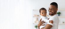 Child Care. Portrait Of Smiling Black Father Holding Newborn Baby In Arms
