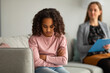 Stress and psychological trauma. Black girl at psychologist session, upset teen turning back, feeling anxiety