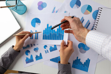 Hands of business people on the desktop. Analysis of financial data, charts and statistics.