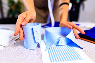 dressmaker woman showing sample collar and cuff for shirt