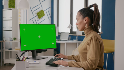 Poster - Business woman looking at display with green screen, using chroma key with isolated background on computer. Company employee working with mock up blank template in office. Copy space