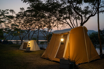 camping tent on campsite with panoramic view in evening sunset. cozy tents for recreation near lake.