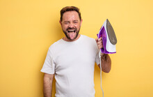 Middle Age Man With Cheerful And Rebellious Attitude, Joking And Sticking Tongue Out. Clothes Iron Concept