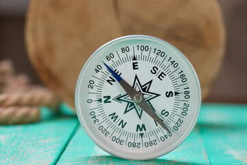 Wall Mural - Compass and rope on wooden texture background