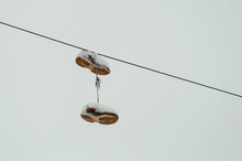 Snow-covered Sneakers Hanging On Wires
