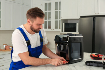 Sticker - Repairman with screwdriver fixing coffee machine at table in kitchen