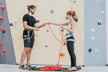 Positive Sportspeople With Rope Near Climbing Wall