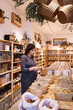 © ADDICTIVE STOCK - Female choosing products in eco friendly store