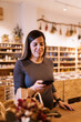 © ADDICTIVE STOCK - Positive female standing at table in eco friendly store