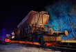 Bunt beleuchteter alter und rostiger Eisenbahn Waggon auf einem Abstellgleis in der Nacht vor Sternenhimmel.
