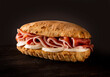 Sandwich with mozzarella and cured raw ham on dark background
