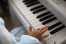 Hand Of Kid On Piano Keyboard.
