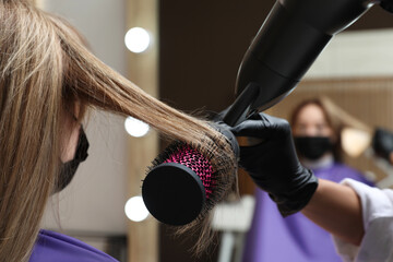 Canvas Print - Professional stylist working with client in beauty salon, closeup. Hairdressing services during Coronavirus quarantine