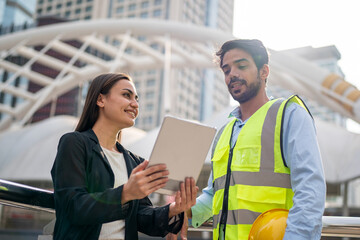 Wall Mural - portrait of an industrial man and woman engineer with tablet in a factory, talking.