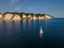 Aerial View Of Sailboat On A Clear And Sunny Morning Near The White Mons Klint Cliffs, Denmark.
