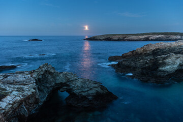 Wall Mural - Full moon on the coast of Galicia, with lighthouse, natural rock arches, etc!