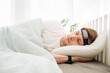 © Girts - Man sleeping on bed with smart sleep headband. Smart sleep tracker. Heartbeat monitor on head. Modern male health monitor. Cozy sleeping bed room. Wearable technology in a daily life to develop habit