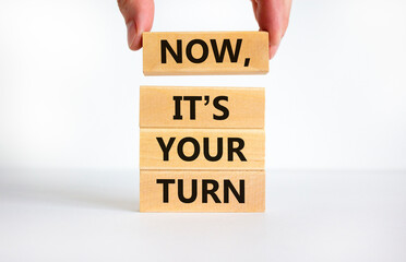 Now it is your turn symbol. Concept words Now it is your turn on wooden blocks. Businessman hand. Beautiful white table, white background, copy space. Business and now it is your turn concept.