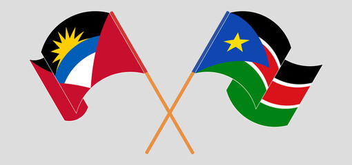 Crossed and waving flags of Antigua and Barbuda and South Sudan