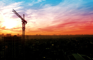 The outline of the city and the crane against the backdrop of the sunset.