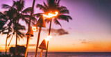Fototapeta  - Hawaii luau beach party at sunset. Hawaiian tiki torches lighted up with fire at luxury resort hotel restaurant. Panoramic banner of hawaiian aloha spirit.