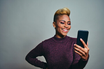 Wall Mural - Female Hipster Taking Selfie Against Gray Background