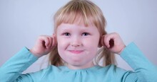 Cute Caucasian Little Blond Girl Making Funny Monkey Face And Laughing.