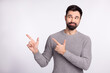 © Tetiana - Photo of young man curious look point fingers empty space promo advert isolated over grey color background